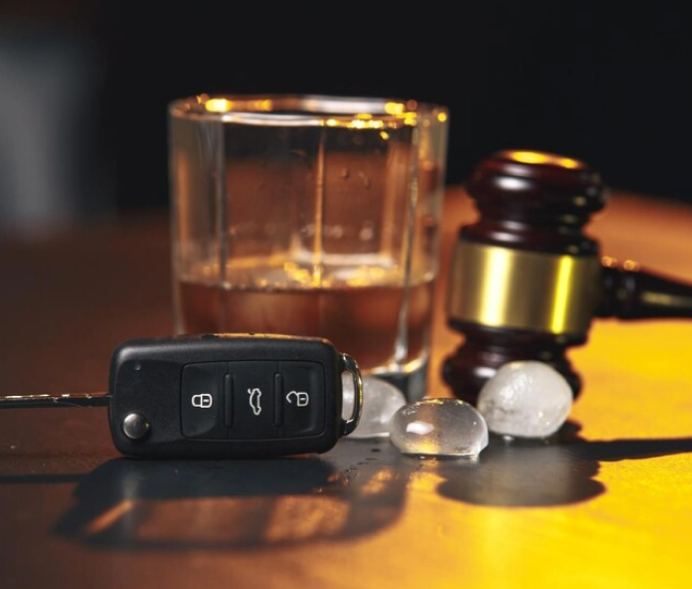 A large glass of wine next to a gravel and keychain
