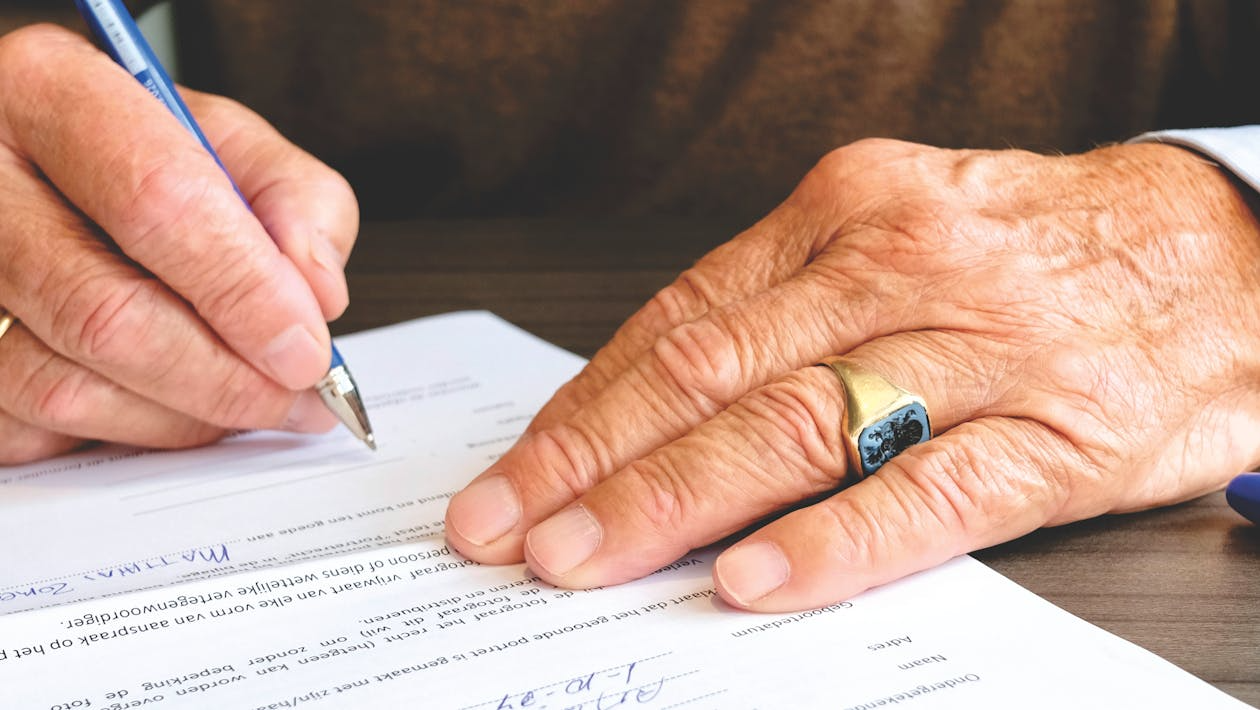 An image of a person signing a paper 