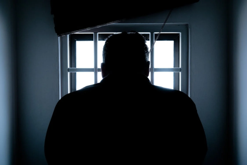 An image of a man behind bars 