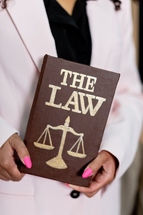 A woman holding a book of “The law”