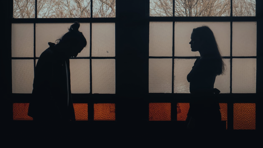 A couple standing at a distance from one another in a dark room